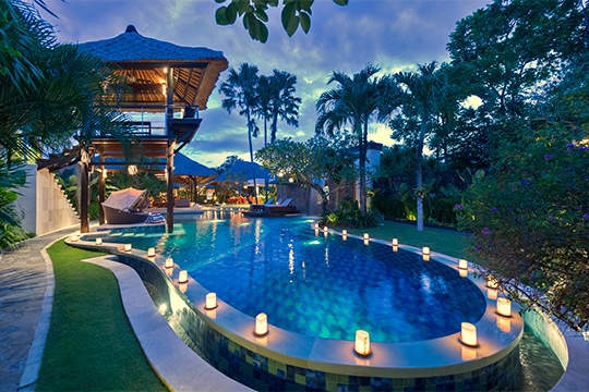 Pool and villa lit up at night